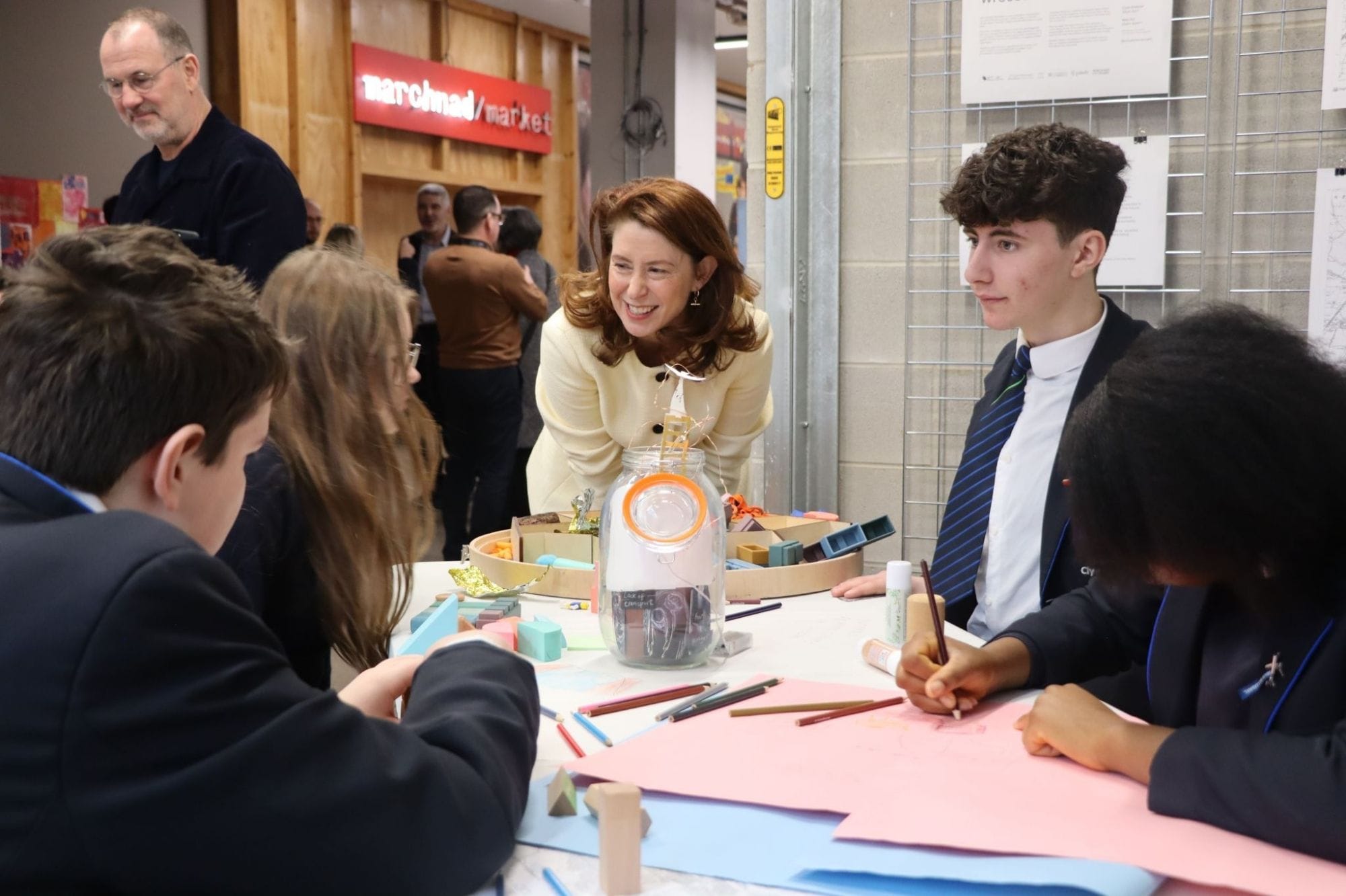 Nina Ruddle talking to three pupils around a table